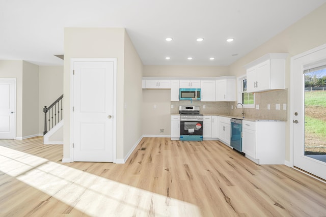 kitchen featuring decorative backsplash, stainless steel appliances, light hardwood / wood-style floors, and white cabinets