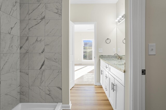 bathroom featuring vanity, tiled shower, and hardwood / wood-style floors