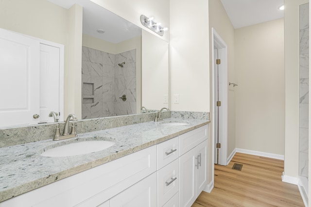 bathroom featuring tiled shower, vanity, and hardwood / wood-style floors