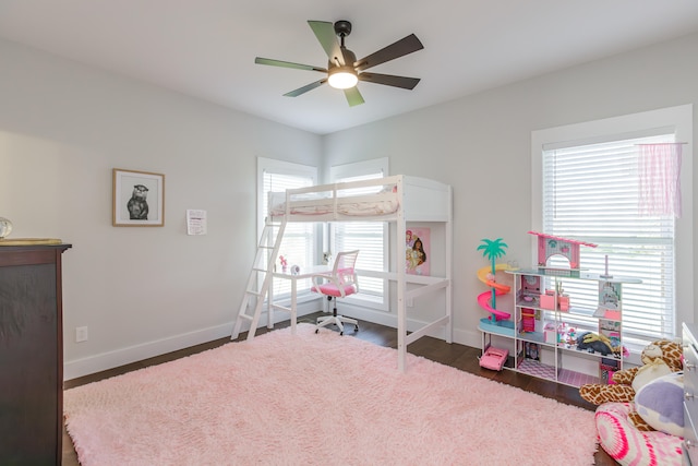 bedroom with multiple windows, ceiling fan, and dark wood-type flooring