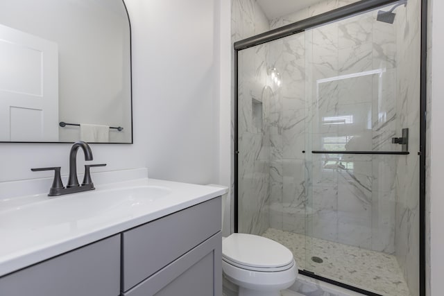 bathroom featuring vanity, toilet, and an enclosed shower