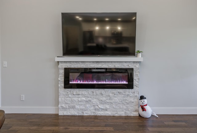 interior details with hardwood / wood-style flooring and a stone fireplace