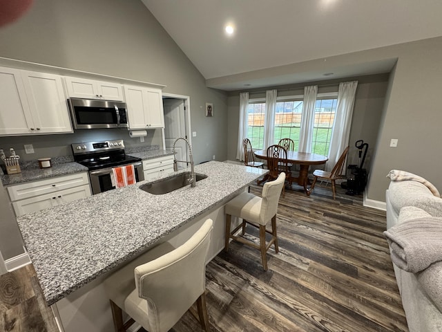 kitchen with white cabinetry, sink, dark wood-type flooring, a kitchen breakfast bar, and appliances with stainless steel finishes