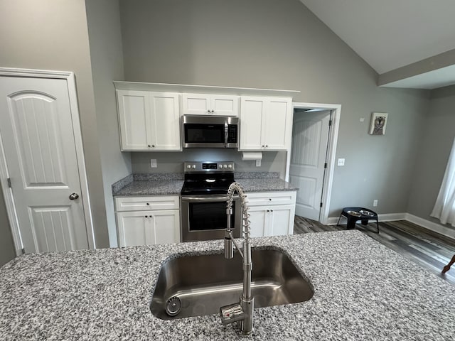 kitchen featuring light stone counters, sink, white cabinets, and stainless steel appliances