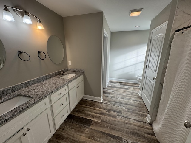 bathroom featuring toilet, vanity, and hardwood / wood-style flooring