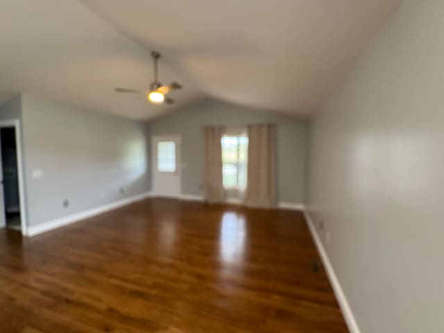 unfurnished living room featuring vaulted ceiling, ceiling fan, and dark hardwood / wood-style floors