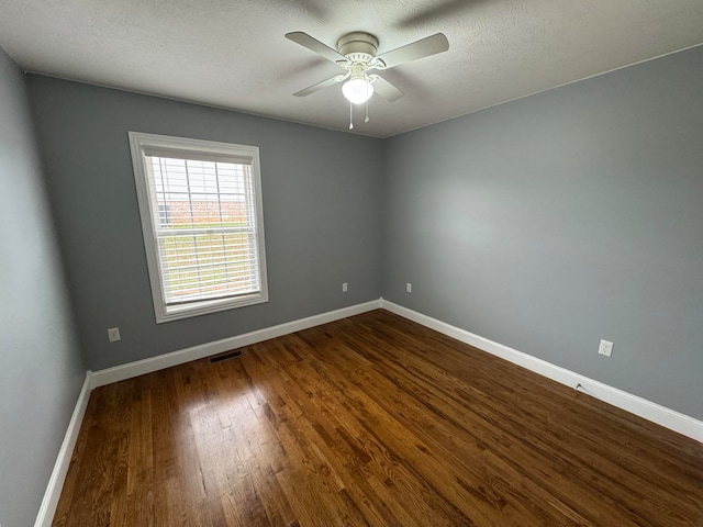 unfurnished room with ceiling fan, dark wood-type flooring, and a textured ceiling