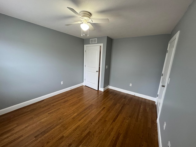 unfurnished bedroom featuring ceiling fan, dark wood-type flooring, and a textured ceiling