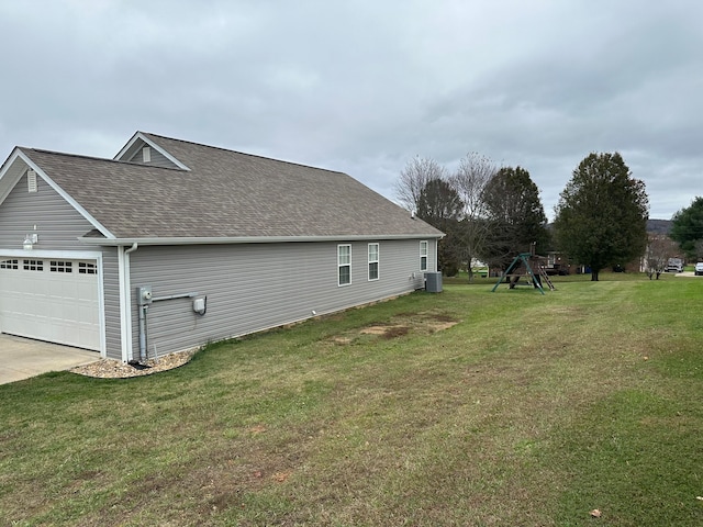 view of home's exterior featuring a garage, a yard, and central air condition unit