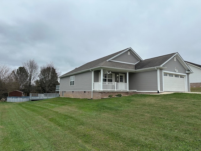 view of front of property featuring a front yard, a garage, and covered porch