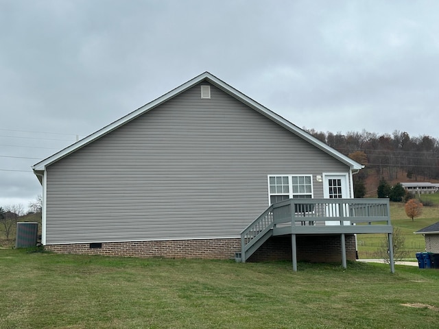 view of side of home with a yard and a deck