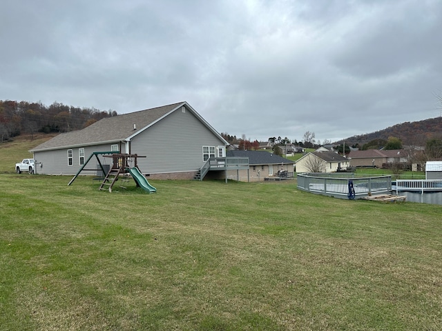 view of yard featuring a playground and a wooden deck