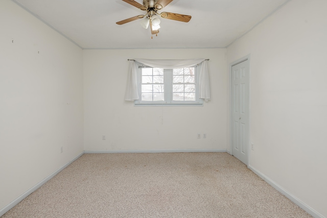 spare room with ceiling fan and light colored carpet