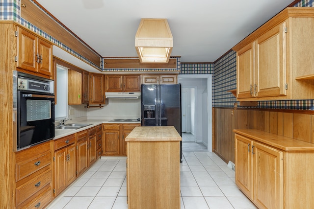 kitchen with wood counters, ornamental molding, sink, black appliances, and a center island