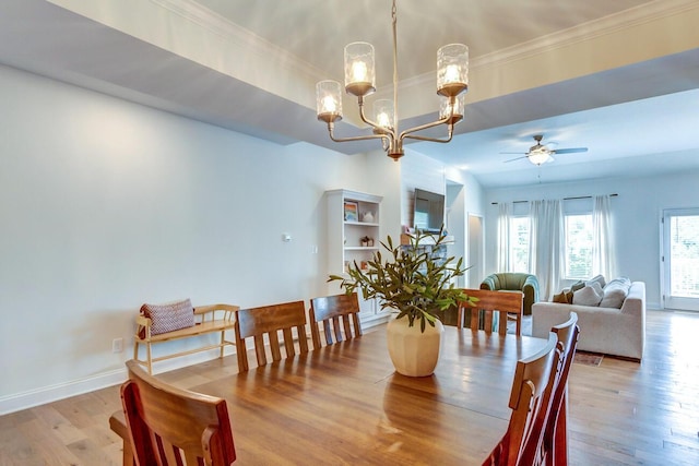 dining area with light hardwood / wood-style floors and ceiling fan with notable chandelier