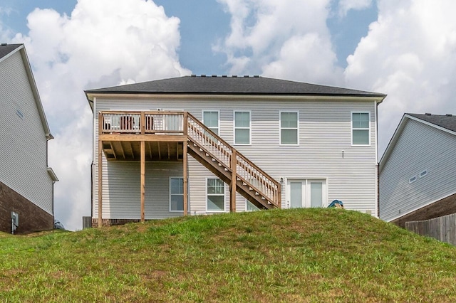 back of house featuring a lawn and a deck