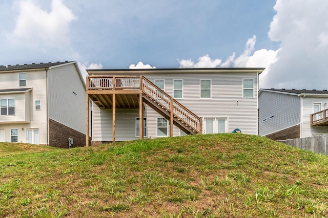 rear view of property featuring a lawn and a wooden deck