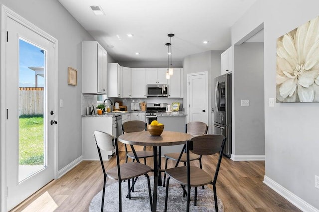 dining area with sink and light hardwood / wood-style flooring