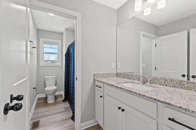 bathroom with hardwood / wood-style flooring, vanity, and toilet