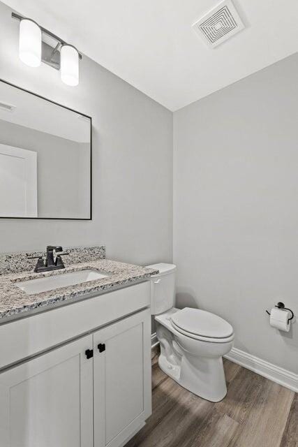 bathroom featuring hardwood / wood-style floors, vanity, and toilet