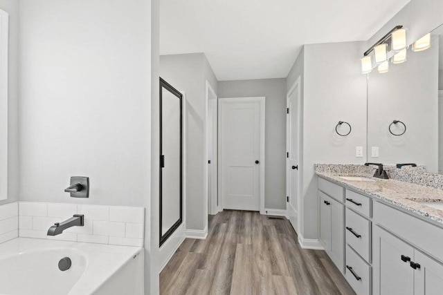 bathroom with vanity, separate shower and tub, and wood-type flooring