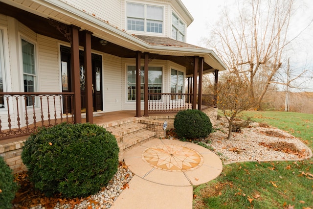 view of exterior entry featuring covered porch