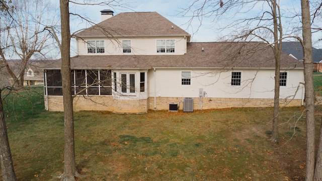 back of property with a sunroom, cooling unit, a lawn, and french doors