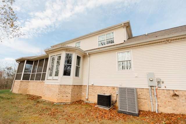 view of home's exterior featuring a sunroom and cooling unit