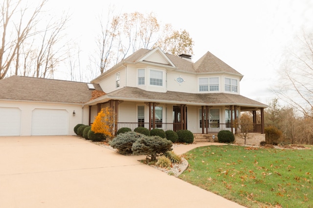 view of front facade with a porch, a garage, and a front lawn