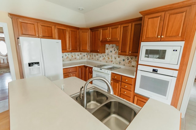 kitchen featuring light hardwood / wood-style floors, white appliances, and sink