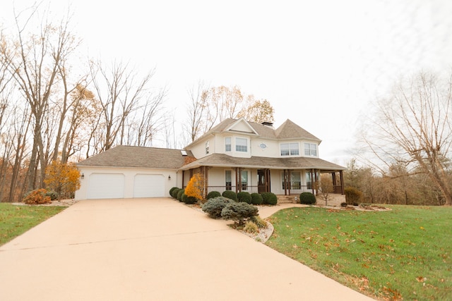 view of front facade with covered porch, a garage, and a front yard