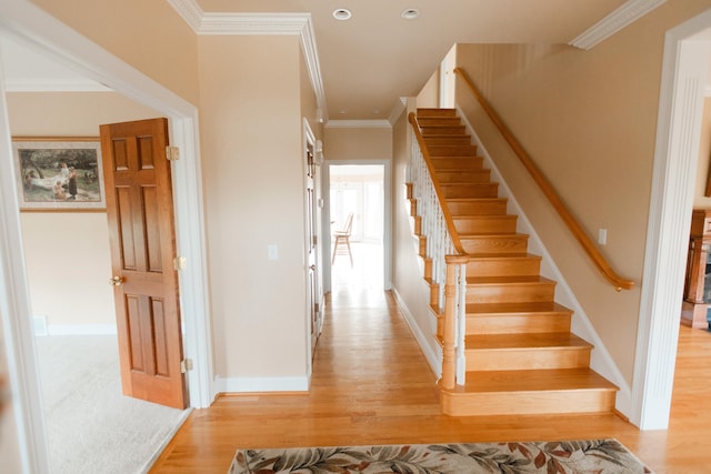 stairway featuring crown molding and hardwood / wood-style floors