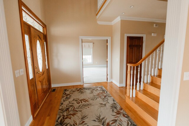 foyer entrance with wood-type flooring and ornamental molding