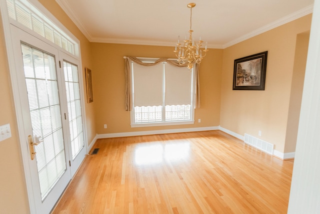 unfurnished dining area featuring plenty of natural light, ornamental molding, a notable chandelier, and light hardwood / wood-style flooring