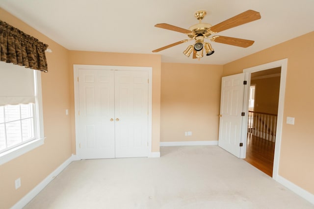 unfurnished bedroom with ceiling fan, a closet, and light colored carpet