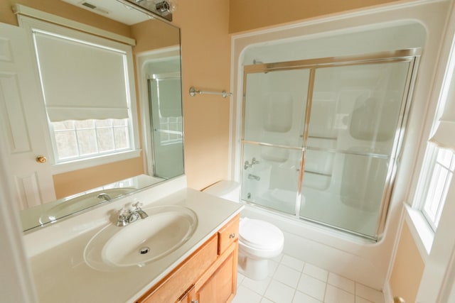 full bathroom featuring shower / bath combination with glass door, tile patterned flooring, vanity, and toilet