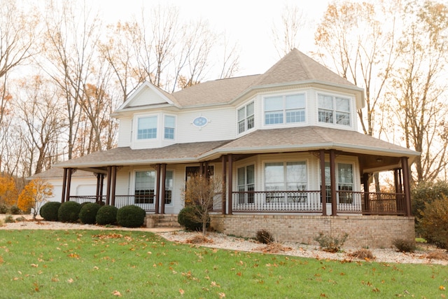 view of front facade featuring covered porch and a front lawn