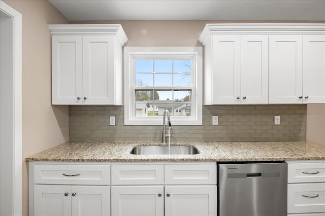 kitchen with white cabinets, light stone counters, stainless steel dishwasher, and sink