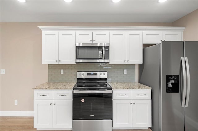 kitchen with white cabinets, light wood-type flooring, and appliances with stainless steel finishes