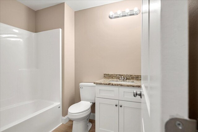 full bathroom with shower / tub combination, hardwood / wood-style flooring, vanity, and toilet