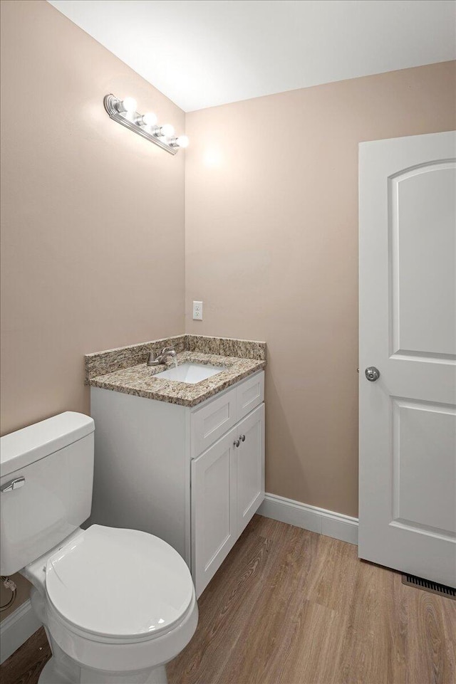 bathroom with vanity, hardwood / wood-style flooring, and toilet