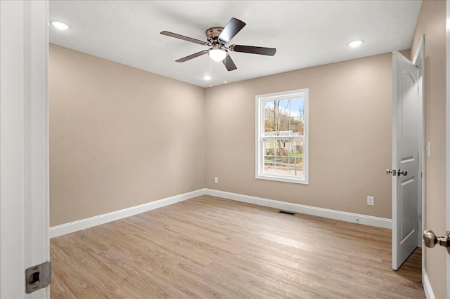 spare room with ceiling fan and light wood-type flooring