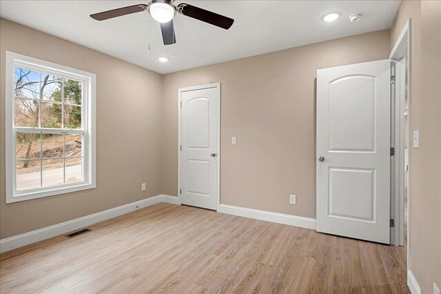 unfurnished bedroom with ceiling fan and light wood-type flooring