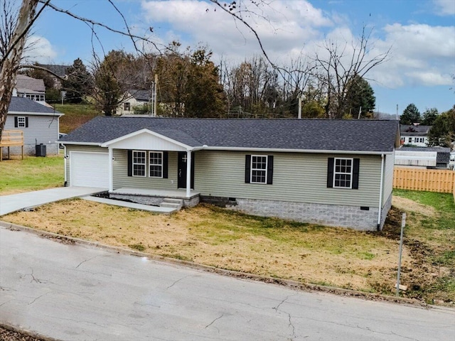 view of front of home featuring cooling unit, a garage, and a front lawn