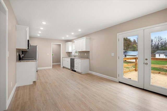 kitchen featuring french doors, light wood-type flooring, backsplash, sink, and white cabinetry