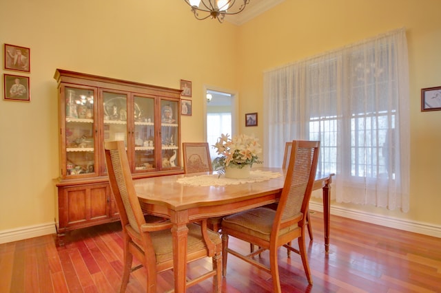 dining room featuring hardwood / wood-style flooring, crown molding, and a notable chandelier