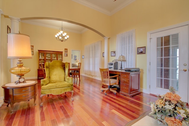 office featuring an inviting chandelier, light hardwood / wood-style floors, ornate columns, and crown molding