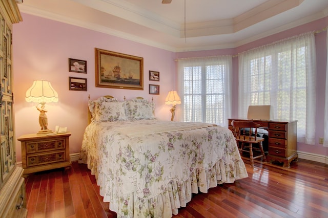 bedroom featuring a tray ceiling, ceiling fan, dark hardwood / wood-style floors, and ornamental molding