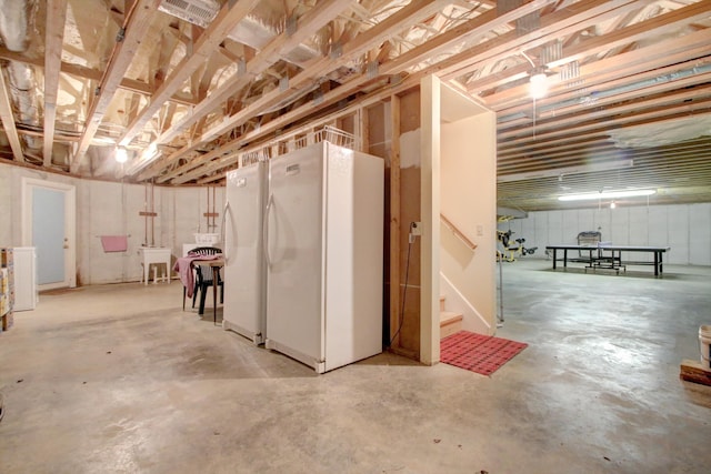 basement with sink and white refrigerator