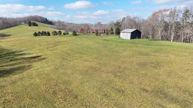 view of yard with an outbuilding and a rural view